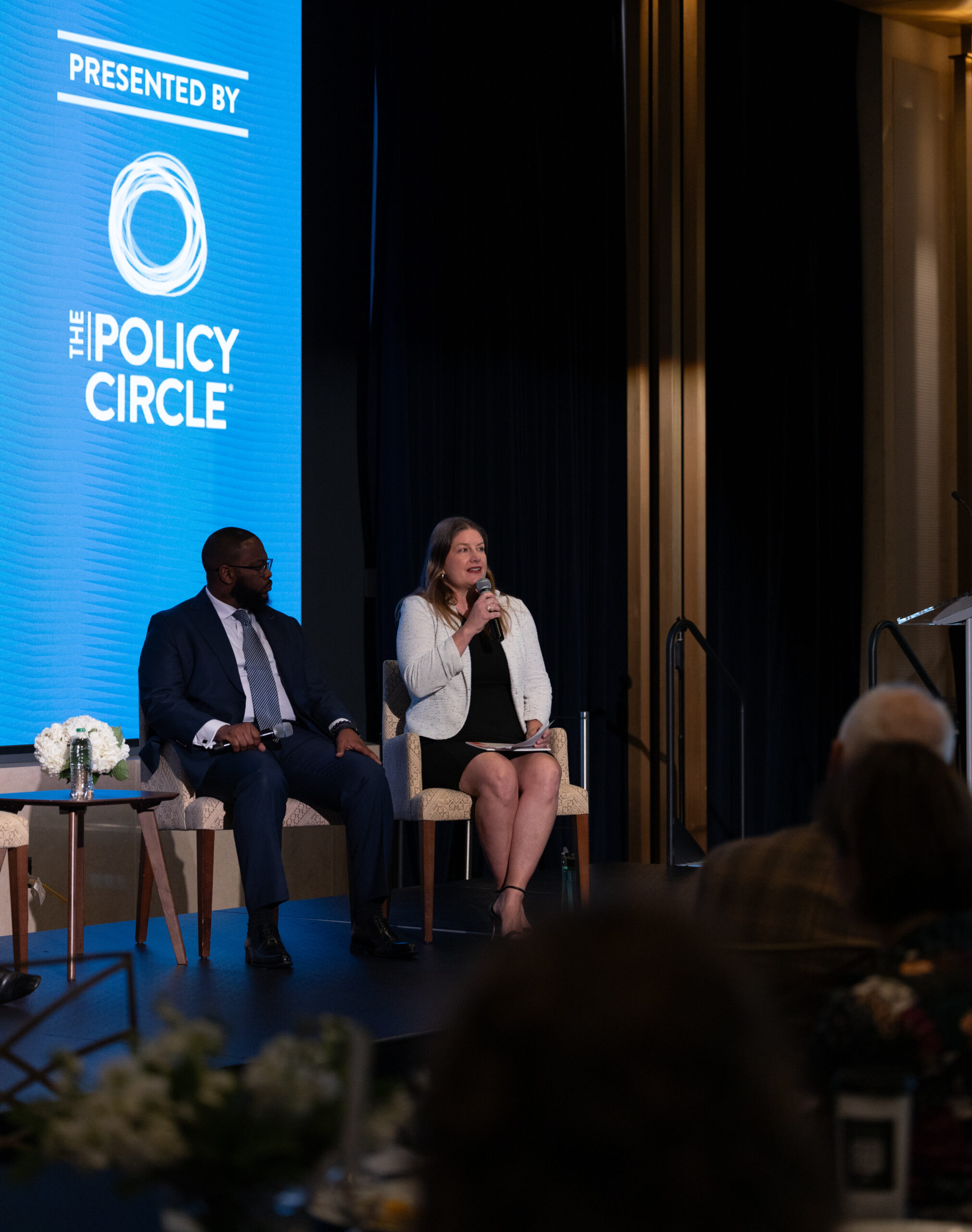 Color image of two people with microphones on a panel at the Faith and Civic Life Symposium.