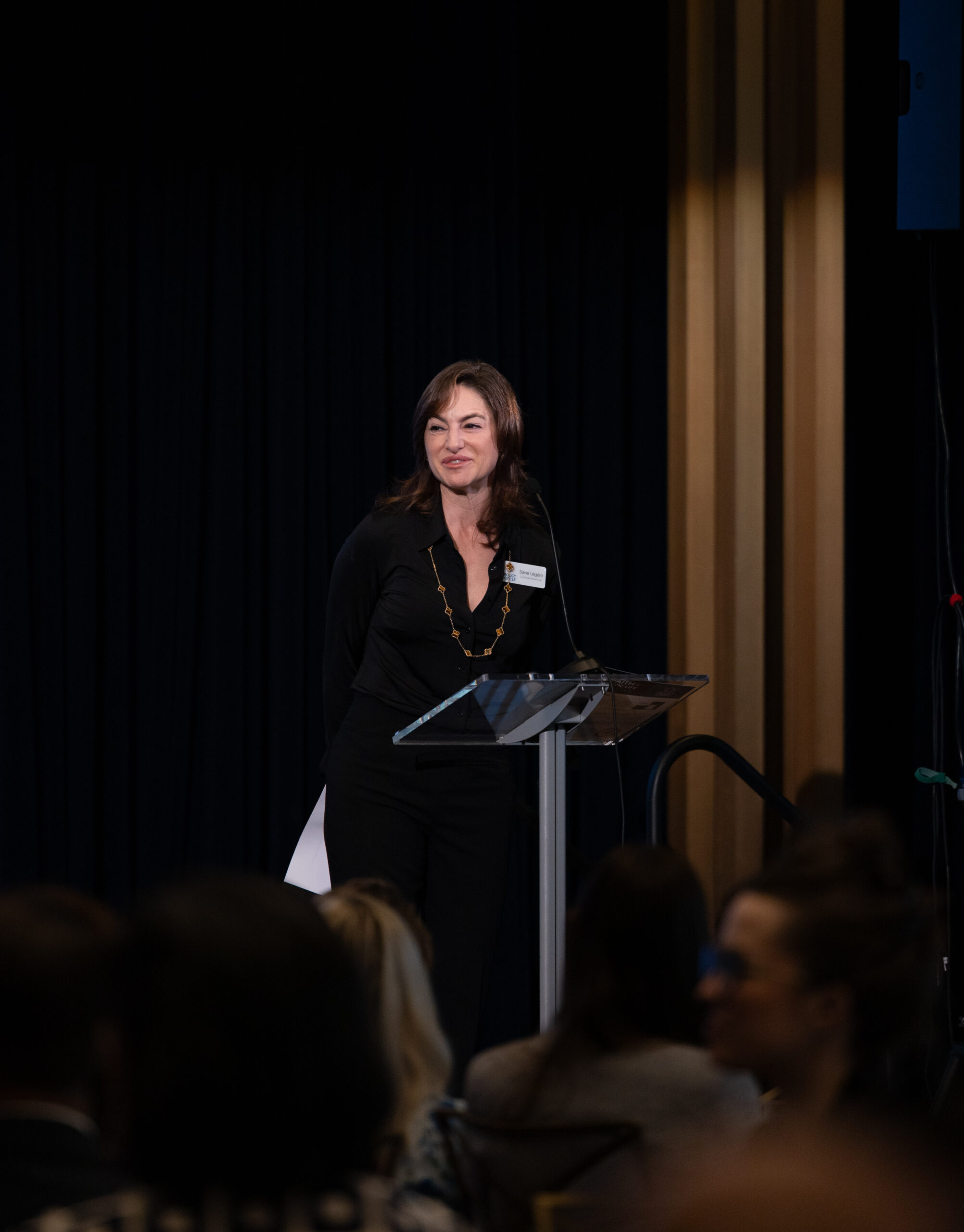 Color photo of Sylvie Légère speaking on stage at the Faith and Civic Life Symposium.