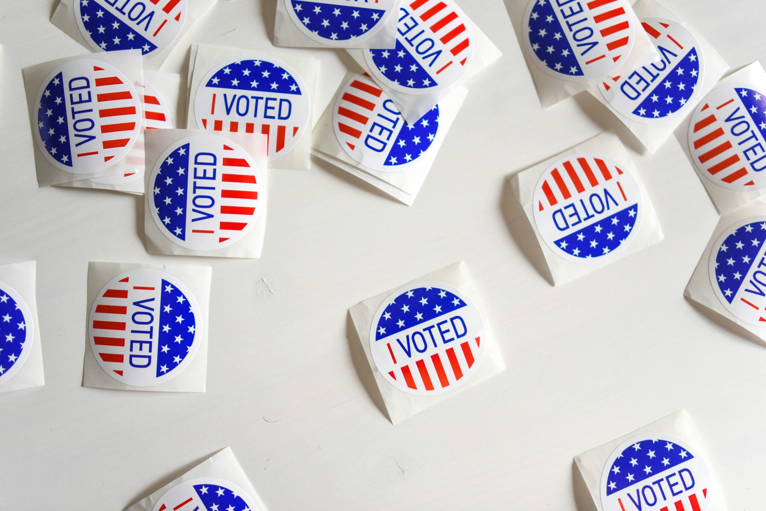 Color photo of scattered "I voted" stickers.