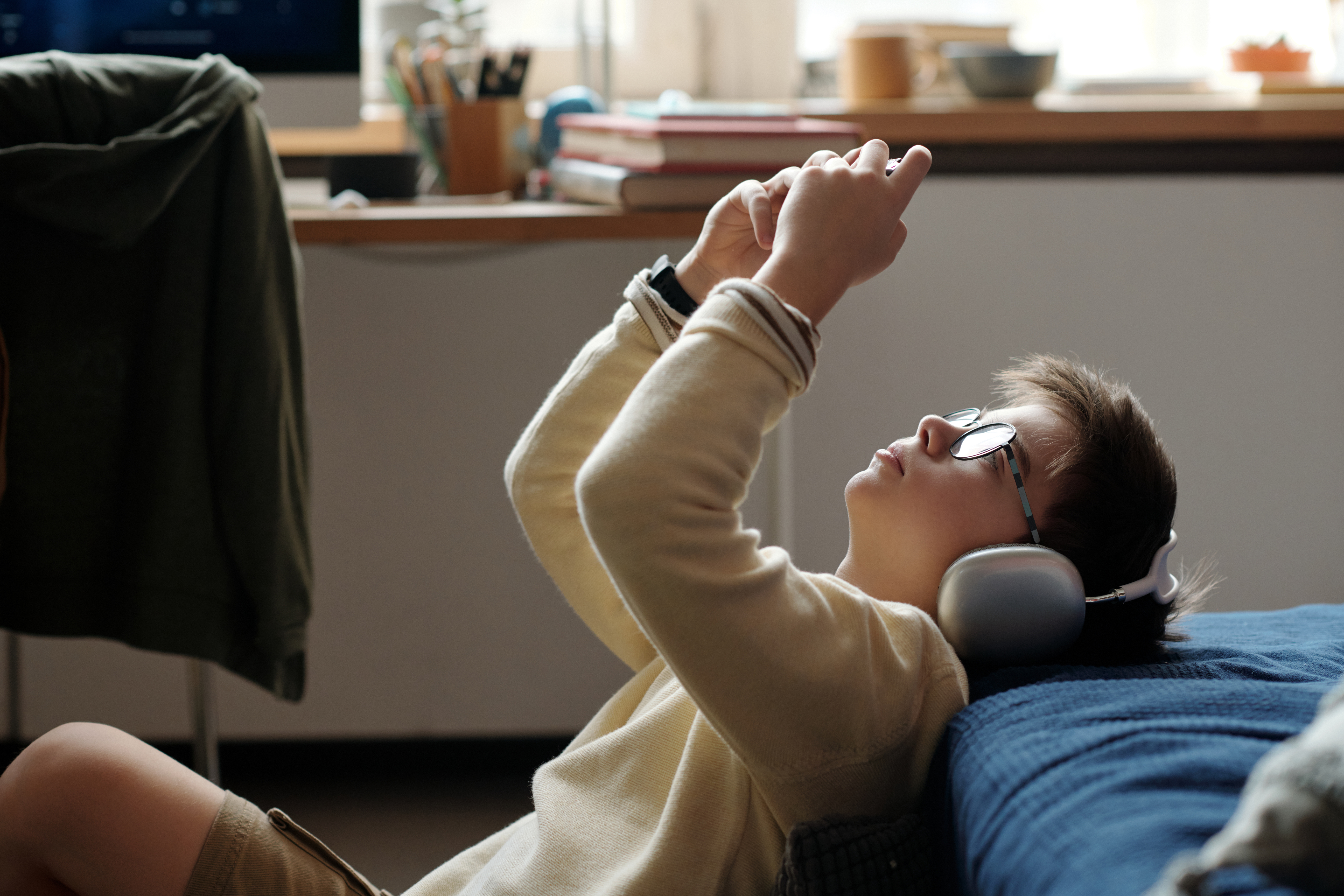 A boy playing a video game with headphones on.